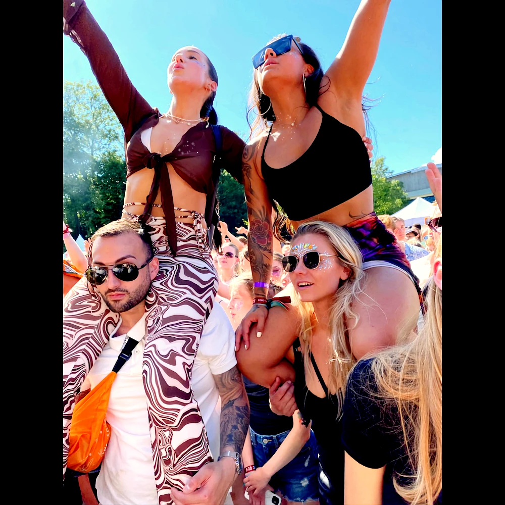 Friends on shoulders at a summer festival wearing plant-based Glitter Eco Lovers glitter